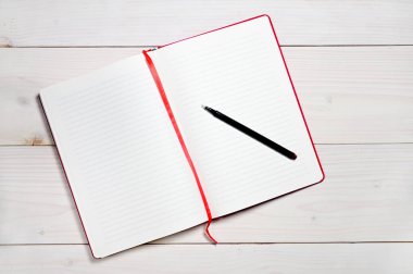 Beyaz ahşap arka plandaki günlük notlar için kırmızı defter