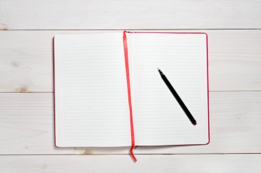 Beyaz ahşap arka plandaki günlük notlar için kırmızı defter