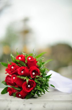 Bir bahar günü, beyaz mermer üzerinde kırmızı düğün çiçeği buketi