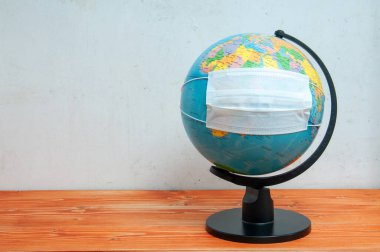 Dünya üzerinde açık yüzeylerin korunması için koruyucu tıbbi maske ve etkili alkol çözeltisi