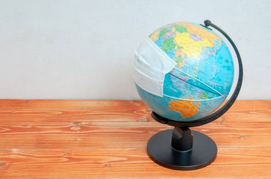 Dünya üzerinde açık yüzeylerin korunması için koruyucu tıbbi maske ve etkili alkol çözeltisi