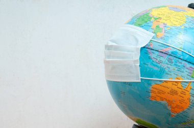 Dünya üzerinde açık yüzeylerin korunması için koruyucu tıbbi maske ve etkili alkol çözeltisi