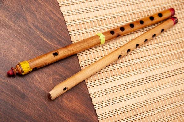 Vintage bambu fife ve flüt bir hasır üzerinde yatıyor