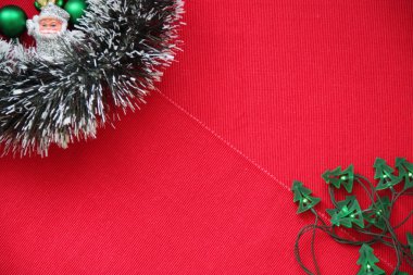 Yeni yıl tinsel, garland, toplar ve Santa Claus kırmızı bir arka plan üzerinde.