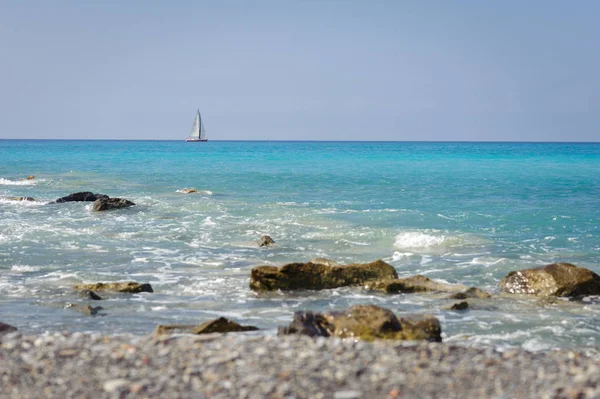 Marinmålning. Kusten av Liguriska havet, med turkost vatten. Segelbåt på horisonten. — Stockfoto