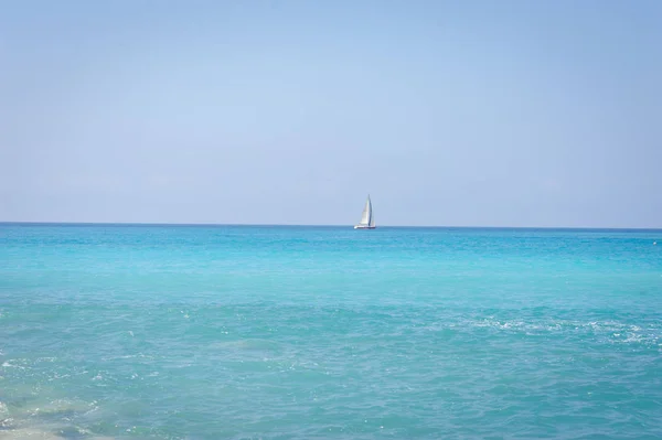 海の風景。青緑色の水と、リグリア海の海岸。地平線上のヨット. — ストック写真