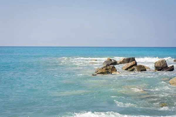 Zeegezicht. De kust van de Ligurische Zee, met turquoise water. Zeilboot op de horizon. — Stockfoto