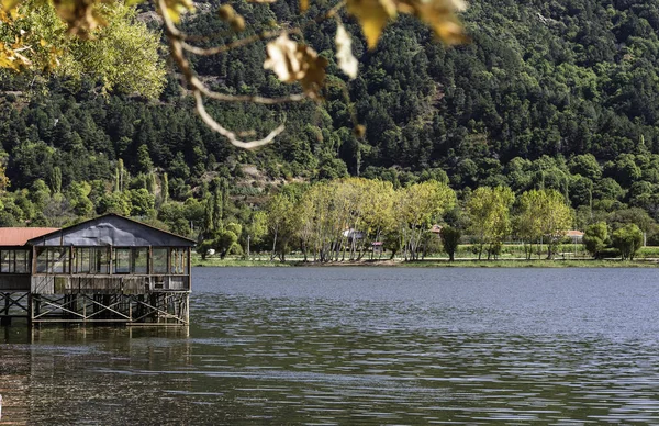 Ormandaki göl. İzmir, Odemis 'teki Golcuk Gölü' nde sonbahar manzarası. Gölün üzerindeki ahşap yapı..