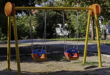 Güneşli bir sonbahar gününde parkta boş salıncaklar..