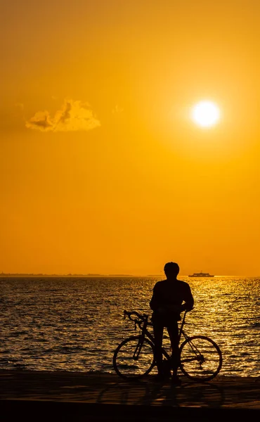Izmir/Turkey-March 06 2019: Silhouette of cyclist at sunset, orange sky and cloud