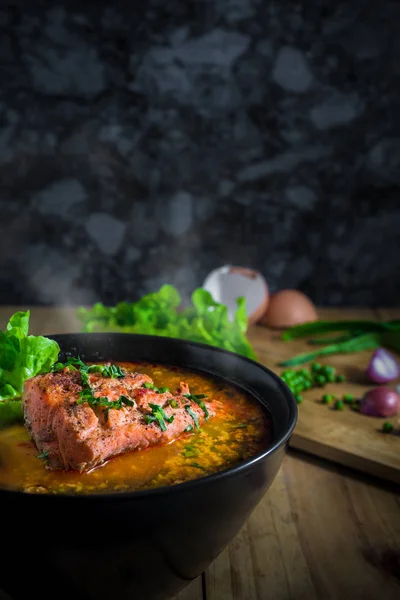 Siyah darbe ve bıçak peper Sebze Doğrama kurulu üzerinde ahşap masa üzerinde de Tomyum somon