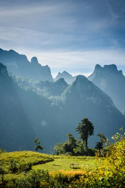 老挝坎斯特的山和蓝天。山前草地上的小家 — 图库照片