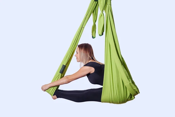 Mujer joven haciendo yoga aéreo en hamaca verde . — Foto de Stock