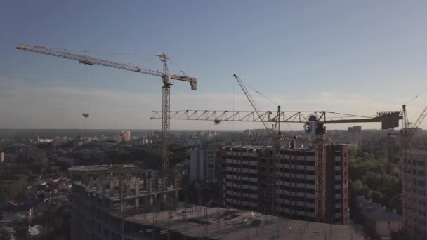 A légi felvétel a Építési daruk és építés alatt álló épületek — Stock videók