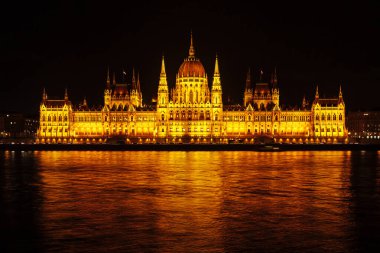 Budapeşte 'deki Macar Parlamentosu binasının gece görüşü. Tuna Nehri 'nde güzel bir ışık ve yansıma.