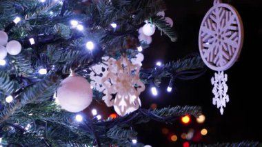 Yeni yıl ağacı geçmişi dekore edilmiş. Yeşil Noel ağacında parıldayan ışıkları olan Noel oyuncakları yakın..