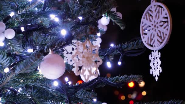 Fondo decorado del árbol de Año Nuevo. Juguetes navideños con luces centelleantes en el árbol de Navidad verde de cerca . — Vídeos de Stock