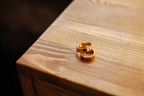 나무 탁자 위에 황금 반지가 놓여 있다 — 스톡 사진