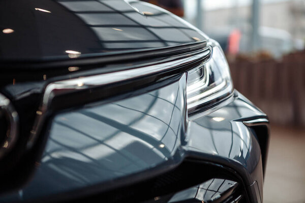 Closeup of a car headlight. Headlight of an expensive new car at a car dealership.