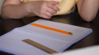 Küçük bir kız masada oturur ve sıkılır..