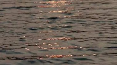 Suyun üzerinde batan güneşin yansıması..