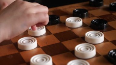 Küçük bir kız kendi kendine dama oynuyor..