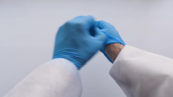 Dokter uit te trekken blauwe latex handschoenen, close-up. — Stockvideo