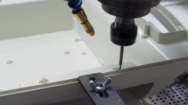 Makine plastik bir parçada delikler açar..