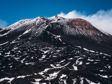 Etna Dağı 'nın tepesinde mavi bir gökyüzüne karşı. Kraterin üzerinde buhar dolaşıyor..