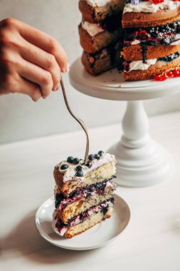 Bir büfede dilimlenmiş pasta ve bir fincan tabağında bir dilim pasta..