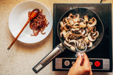 Kadın eli, şampiyonları tavada yağlıyor. Üst görünüm