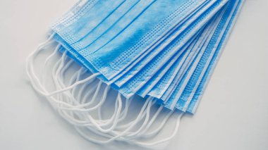 Koruyucu sağlık maskeleri masanın üstünde üst üste yatar..