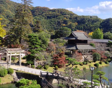 İwakuni, Japonya - 14 Kasım 2019: Kinunkaku Sarayı (yaklaşık Xix c.) İwakuni kalesi yakınlarındaki Kikko tapınağı. Pavilion eski kale hendeğinin yanında ve kale kulesine benziyor.