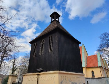 Prague, Czech Republic - March 4, 2020: Black bell tower (1482) of Church of Saint Michael the Archangel (founded in 13th c.) in Podoli district of Prague. Cultural monument of Czech Republic