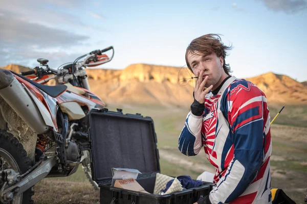 Ciclista relaxar montanhas perto de moto, fumaça de antena — Fotografia de Stock