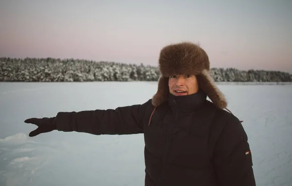 Człowiek w futrze snow zima pokazując ręką do lasu — Zdjęcie stockowe