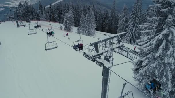 Snowboard d'hiver et vol de drone de ski dans le téléski de montagne au-dessus de l'ascenseur et des peuples — Video