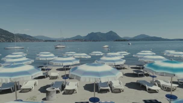 Praia itália como maggiore lago feriados verão férias drone voo guarda-chuva — Vídeo de Stock