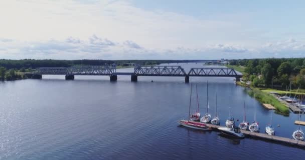 Yahts navires et bateaux sur la rivière Lielupe près du pont de train Jurmala drone vol — Video