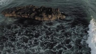 Kayalıklarda dalgalar kırılıyor Batu Balong plajı Bali Adası 4k İHA uçağı