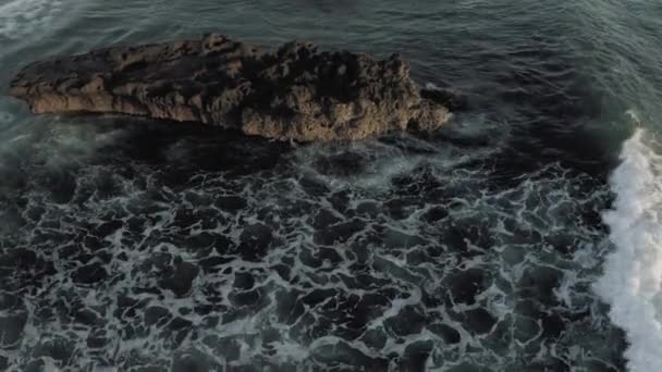 파도가 발리 해변에 있는 바투를 따라 바위에 부딪치다 4K 드론 비행 — 비디오