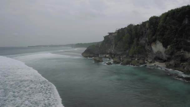 Vågor bryter på klipporna på Bali Island Beach 4k drönare flygning — Stockvideo