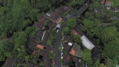 Ubud şehrindeki Bali Adası 4k İHA uçuşunda arabalar ve bisikletler yolda.