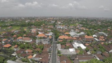 Canggu şehrinde arabalar ve bisikletler Bali Adası 4k İHA uçuşunda.