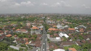 Canggu şehrinde arabalar ve bisikletler Bali Adası 4k İHA uçuşunda.