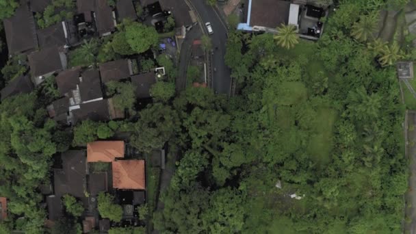 Carros e bicicletas na estrada em Ubud cidade Bali ilha 4K Drone voo — Vídeo de Stock