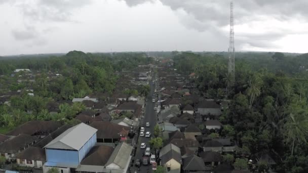 Samochody i rowery na drodze w mieście Ubud Bali wyspa 4k Drone lot — Wideo stockowe