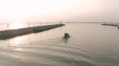 Balıkçı teknesi ve deniz feneri Asya 'da gün batımı zamanı