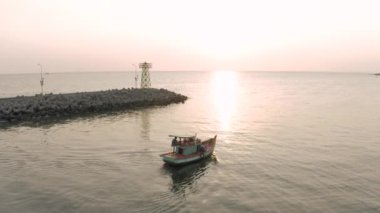 Balıkçı teknesi ve deniz feneri Asya 'da gün batımı zamanı