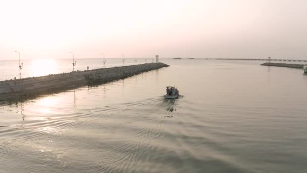 Рибний човен і морський маяк пірнають під час заходу сонця в Азії — стокове відео